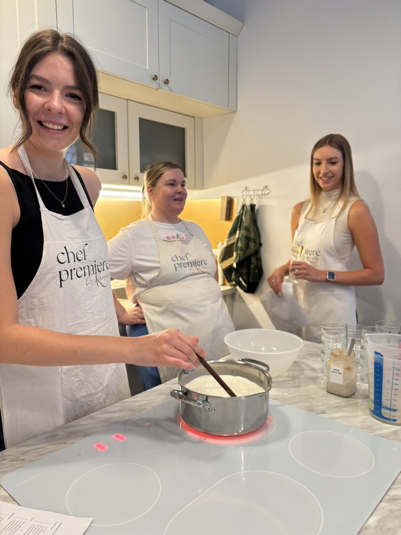 Csapattag mosolyogva keveri a panna cotta alapját a főzőstúdióban